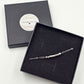 A personalised sterling silver beaded chain Morse Code bracelet displayed inside an open black presentation box, with the matching closed box and circular Classique Jewellery label visible behind it on a light background.